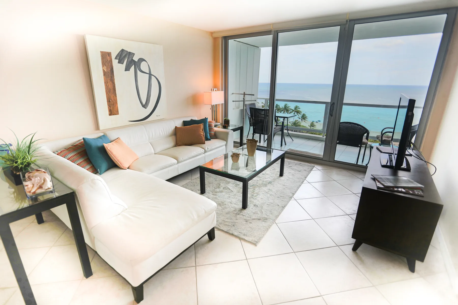 Bright living room opening to an ocean-view balcony